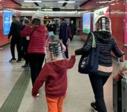 Pasajeros chinos usan botellas de plástico en la cabeza para protegerse del coronavirus